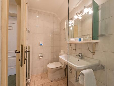 Ein komplett eingerichtetes Badezimmer mit Toilette, Dusche und Waschbecken.