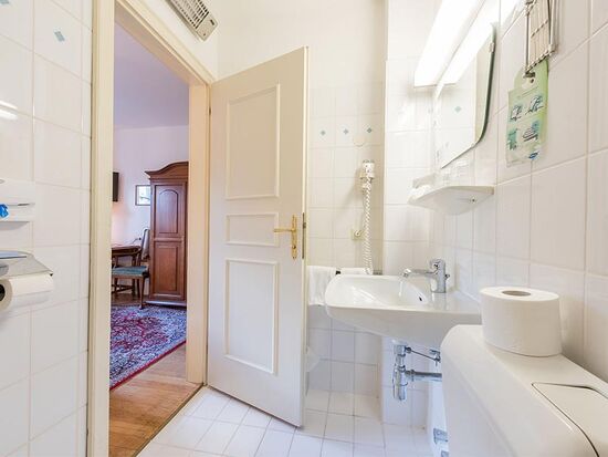 Ein weißes Badezimmer mit Toilette, Waschbecken und Dusche.