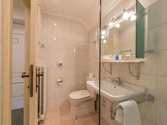 Ein komplett eingerichtetes Badezimmer mit Toilette, Dusche und Waschbecken.