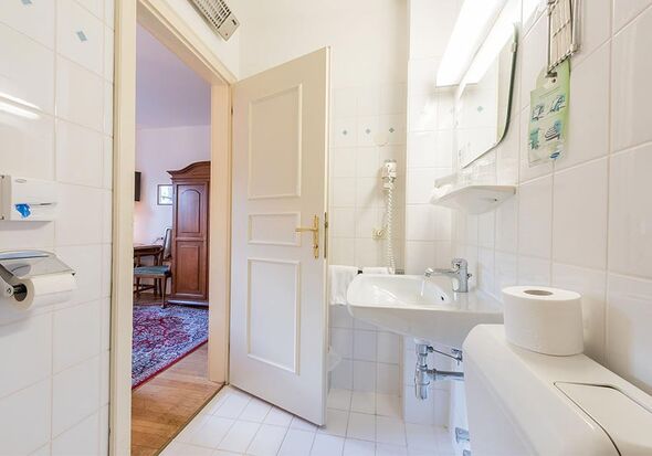 A white bathroom with toilet, sink and shower.