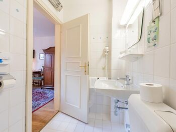 Ein weißes Badezimmer mit Toilette, Waschbecken und Dusche.